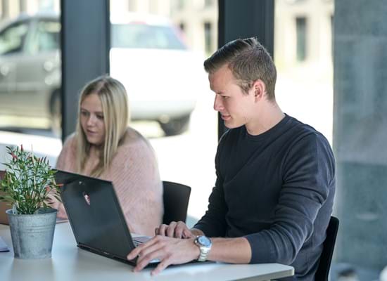 To studerende der sidder ved en computer